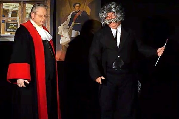 Der Richter im Talar und ein Zeuge mit wilder Perücke vor Gericht